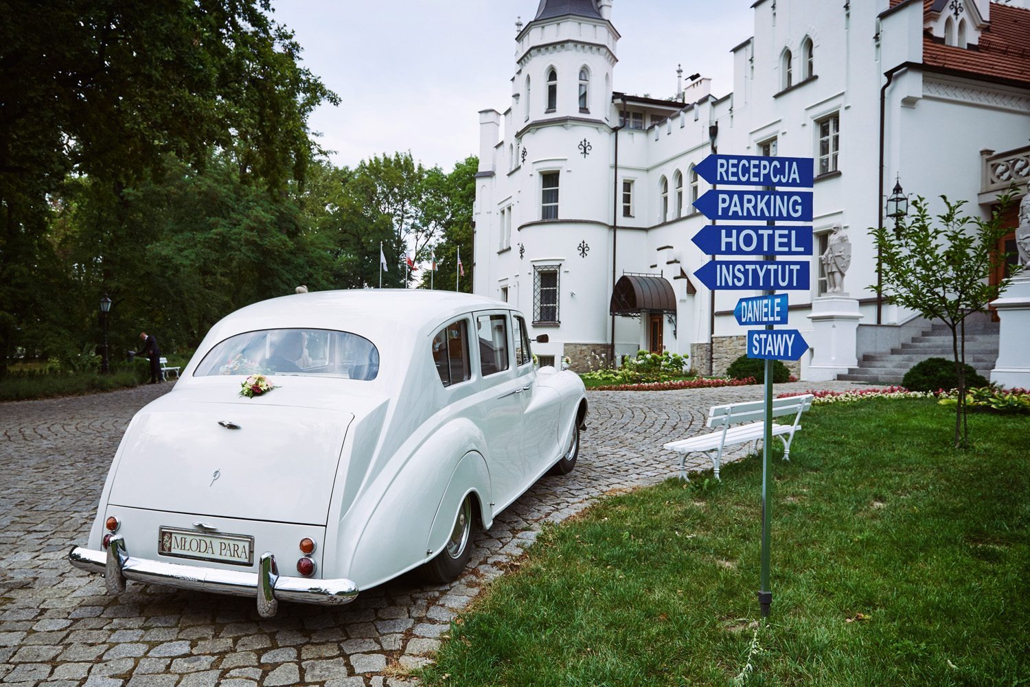 Biała limuzyna Pary Młodej pod Zamkiem Sulisław - fotografia ślubna Opole