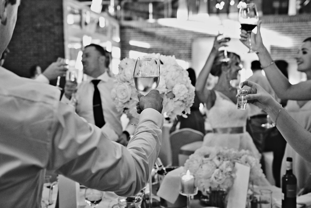 goście podnoszą toast weselny do fotografii ślubnej